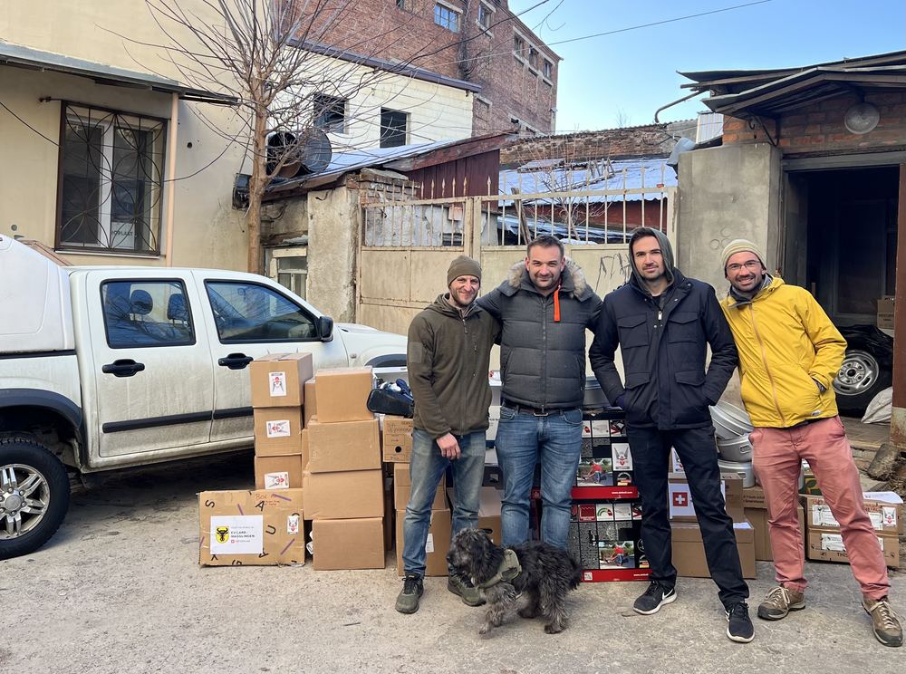 Remise de biens humanitaires&nbsp;: bénévoles avec des cartons devant un dépôt en Ukraine